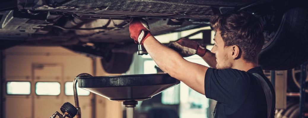 Mechanic undertaking oil change